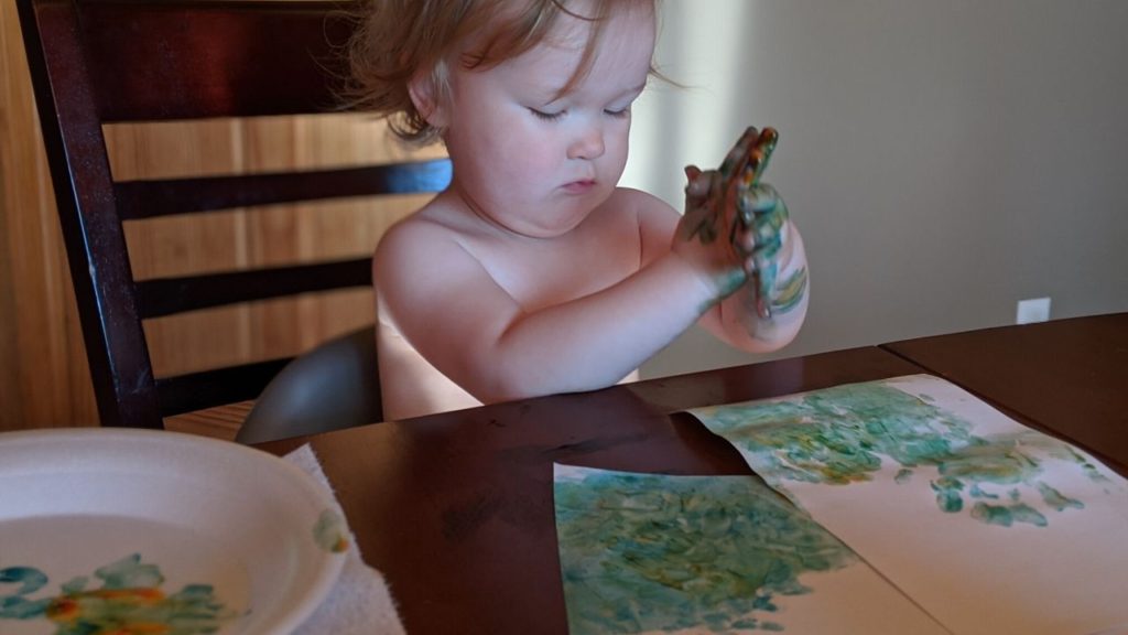 photo of toddler playing with finger paints