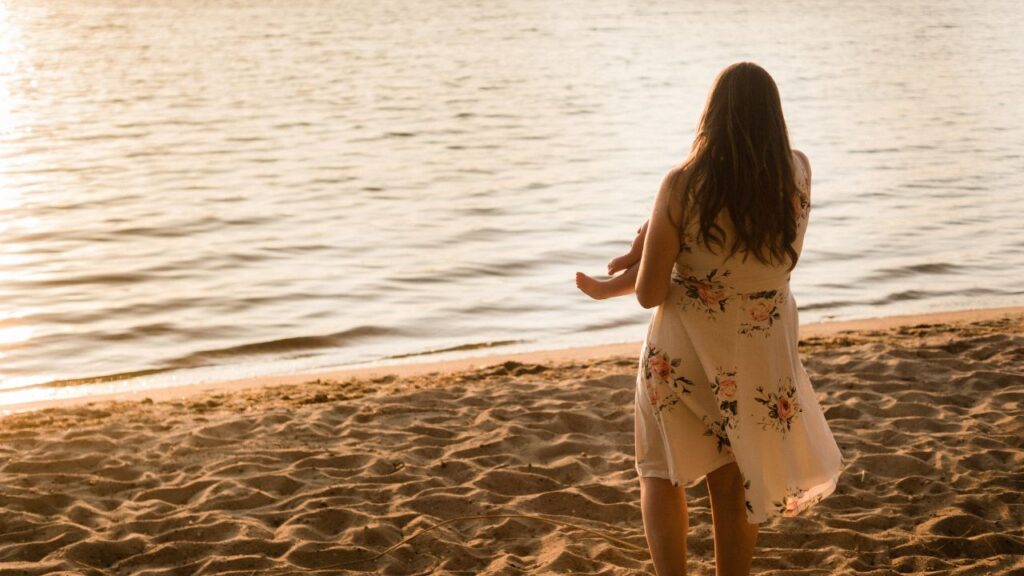 me holding my child as the sun sets on the beach