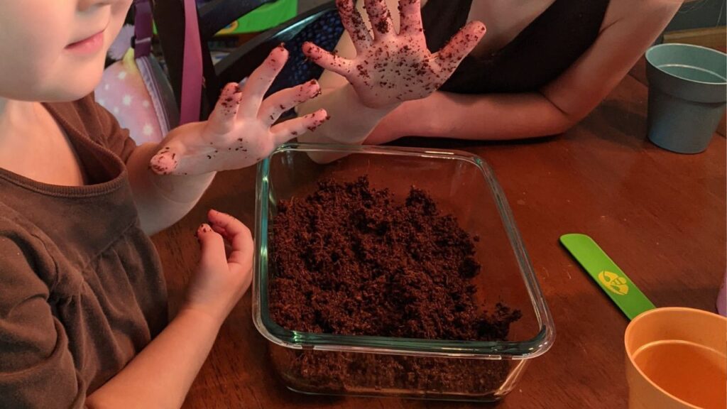 my daughters holding up dirty hands as they work on their herb garden -- a great consumable gift for kids!