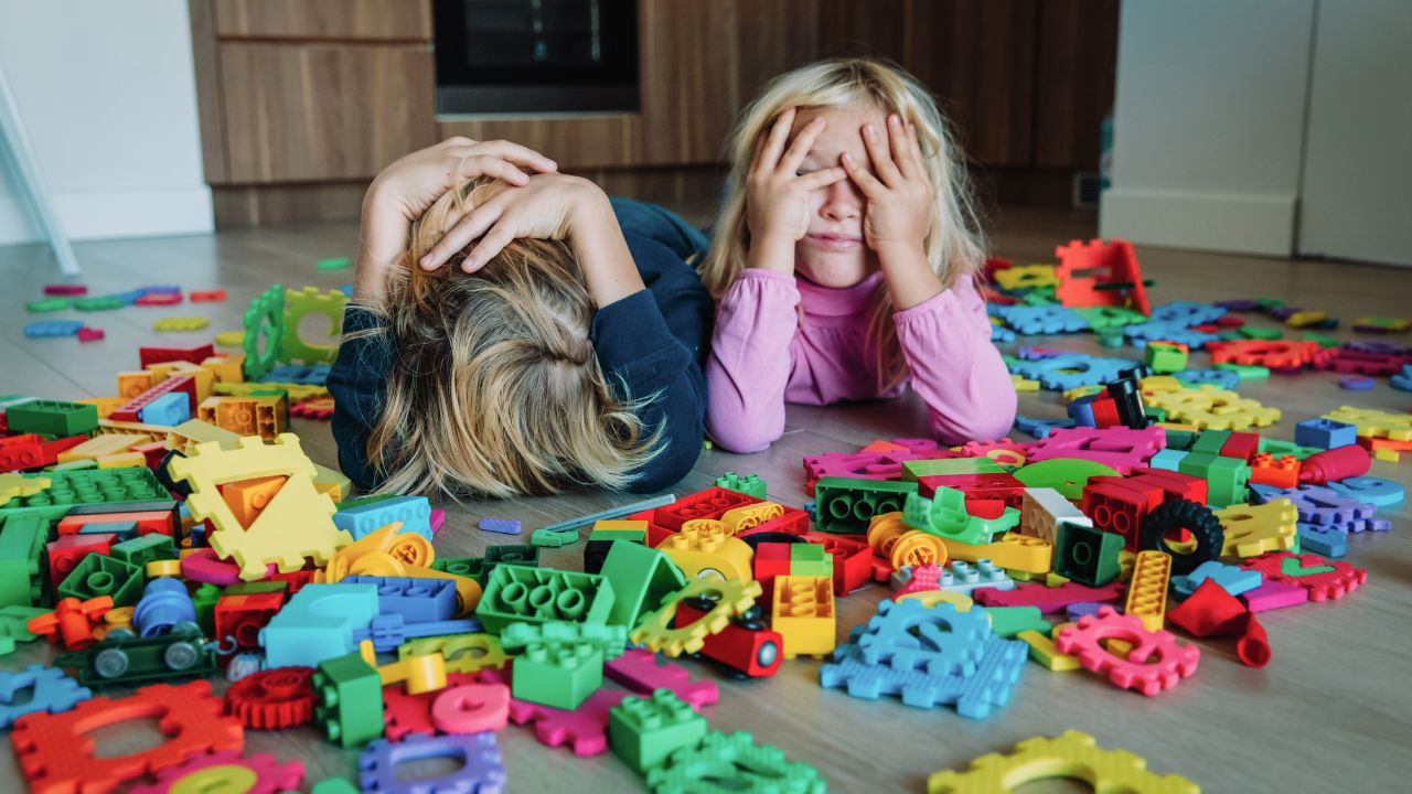 kids on floor with too many toys scattered around